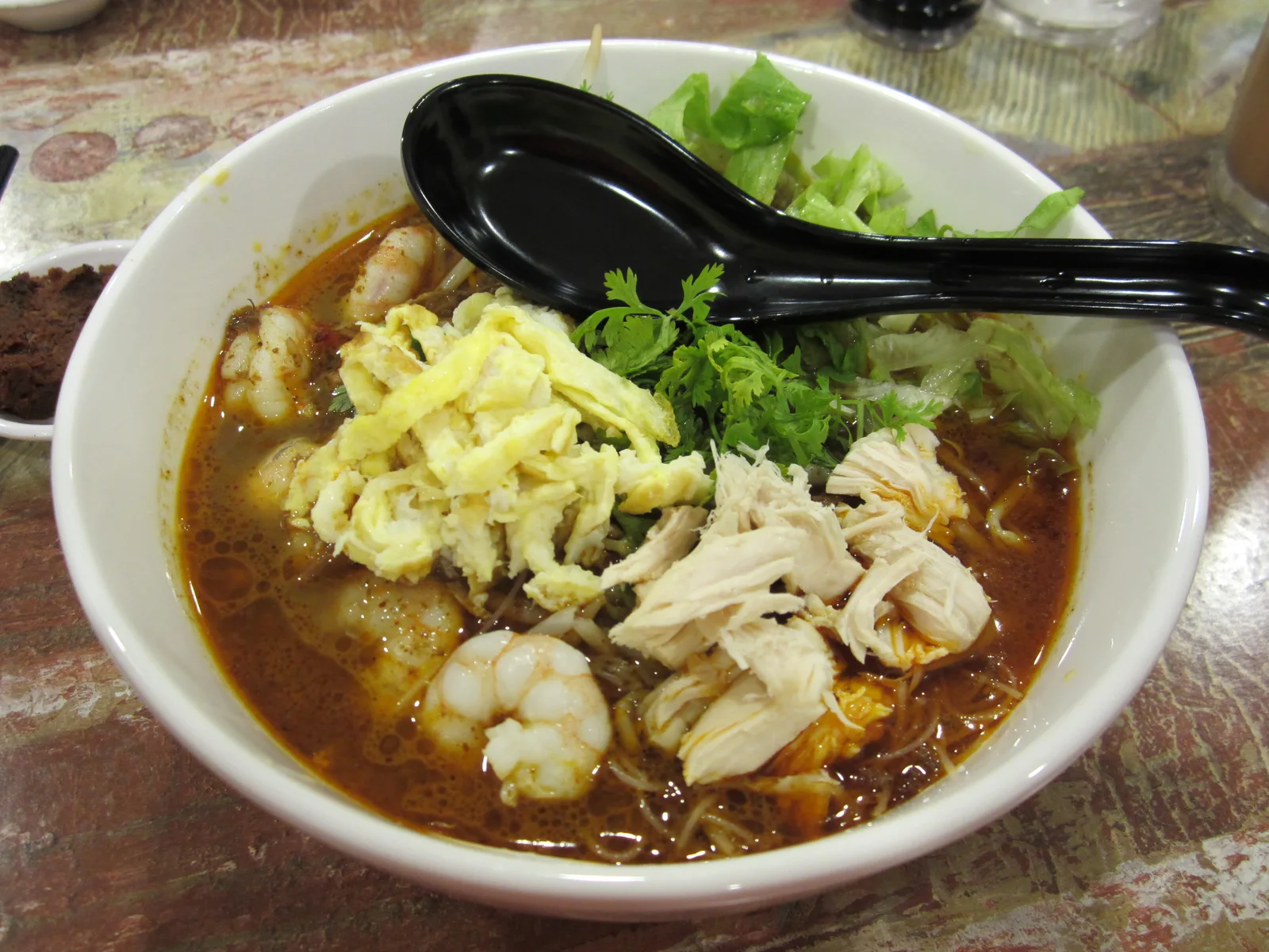 Sarawak Laksa mit Garnelen, Nudeln und Omelettstreifen